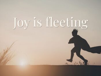 child silhouette running with cape at sunset