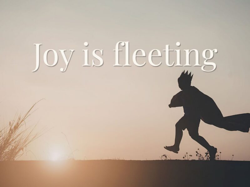 child silhouette running with cape at sunset